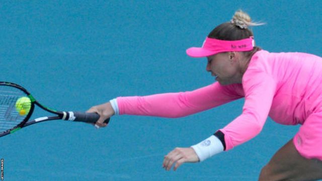 Vera Zvonareva playing against Danielle Collins at the 2022 Miami Open, with a 'no war' message written on her visor hat