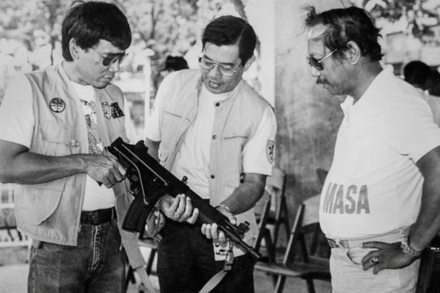 Duterte (esquerda) posa com uma metralhadora na cidade de Davao
