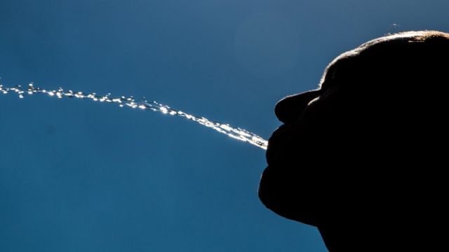 Hombre escupiendo agua