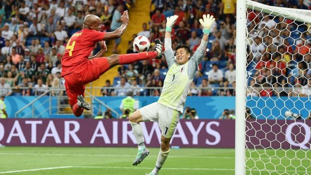 El defensa de Bélgica, Vincent Kompany (izquiera) trata de anotarle un golal portero de Japón, Eiji Kawashima durante el encuentro Bélgica-Japón el 2 de julio.