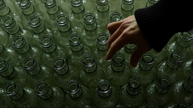 Бутылки водки и рука
