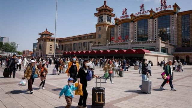 People walk outside the Beijing Railway Station in Beijing, China, 29 April 2023. Chinese authorities are expecting 19 million trips to be made across China"s railway network ahead of the five-day Labour Day holiday.