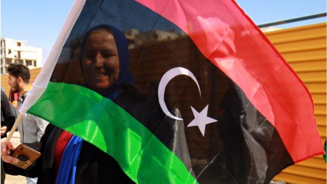 امرأة تحمل علم ليبيا