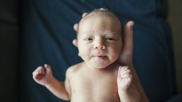 Una mano sujeta a un bebé
