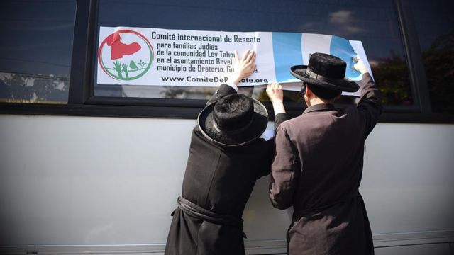 Members of Lev Tahor hold a placard