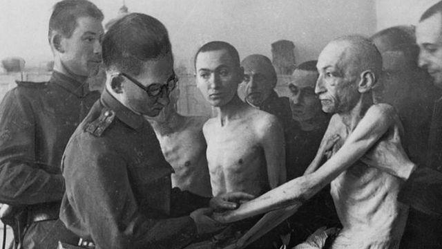 Um médico militar soviético examina um sobrevivente (fotografia tirada no momento da libertação do campo pelo Exército Vermelho) em 27 de janeiro de 1945