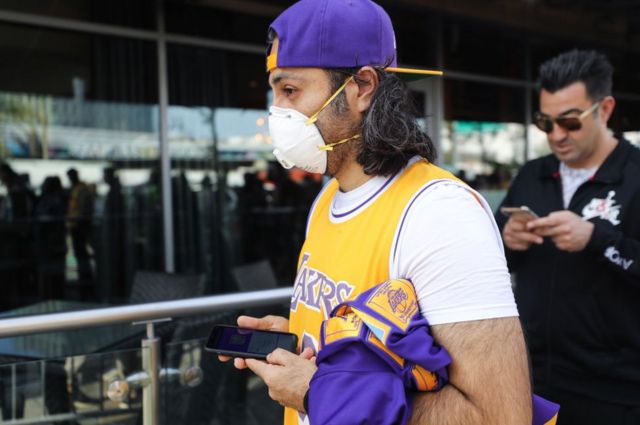 A Kobe Bryant fan wears a mask to his memorial service in LA on Monday