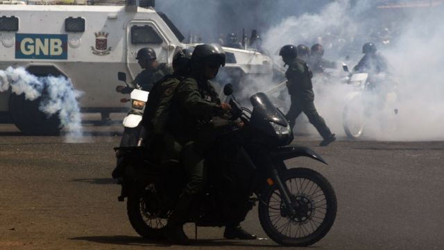 Agentes de la Guardia Nacional, rodeados de gas en una protesta.
