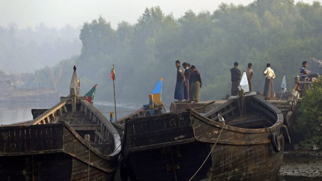 Muslim people stand near the boat near the Border Check Point of Maungdaw town, Bangladesh-Myanmar border, Rakhine State, western Myanmar, 22 December 2016
