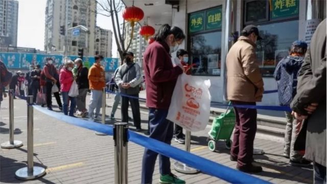 中国持续的封锁措施将对经济造成影响（图为人们排队在北京的一家商店购买食品）。(photo:BBC)