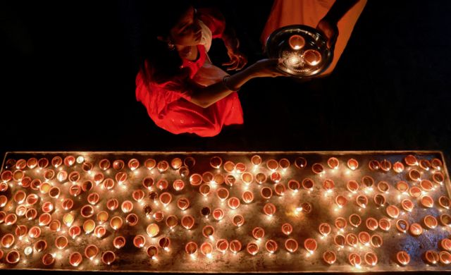 کلمبو، سریلانکا؛ یک دختر هندو چراغ‌های روغنی  را برای مراسم مذهبی در معبد هندو پونامبالا وانشوارام آماده می‌کند
