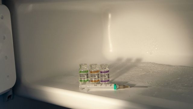 Foto de ampolas e uma seringa dentro de um freezer