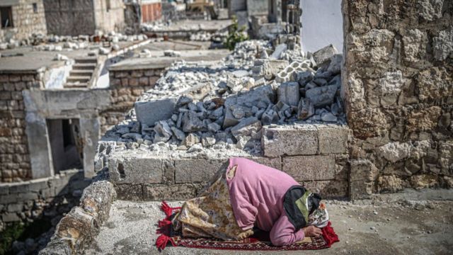 Una mujer entre los edificios destrozados en Idlib, Siria.
