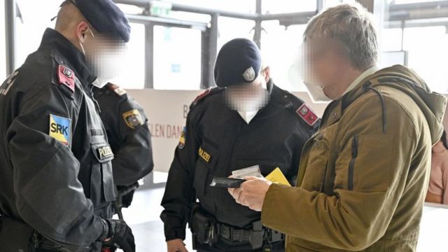Austrian police officers check a man's identity and vaccination certificate during a control in Voesendorf, district Moedling, Austria, on November 16, 2021