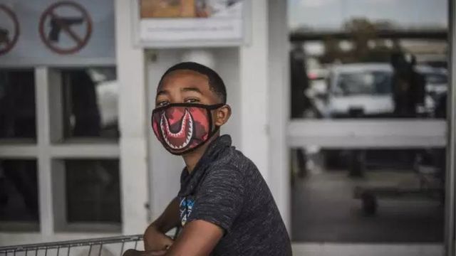 Covid-19 Coronavirus Pandémique Jeune Homme Portant Des Vêtements D'hiver  Dans La Rue De La Ville Portant Un Masque Facial