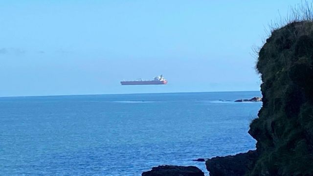 Hovering ship photographed off the coast of Cornwall