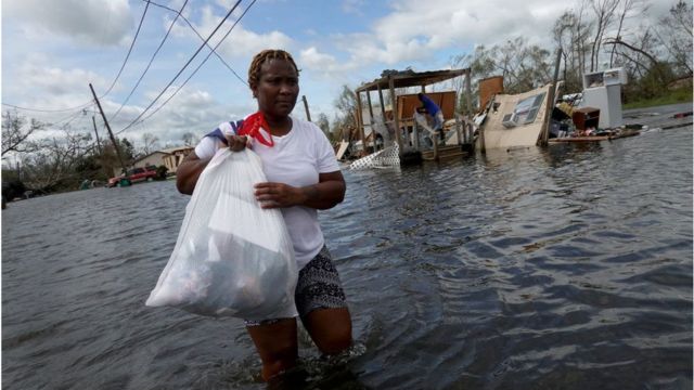 颶風過後，婦女用袋子裝著自己的東西