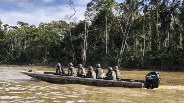 Militares em barco no rio