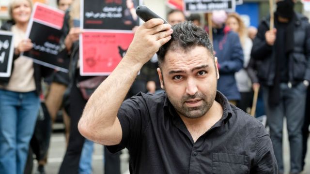 Hombre se corta el pelo en manifestaciones en Bélgica.