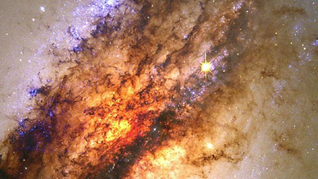 Uma galáxia desaparecendo em um buraco negro