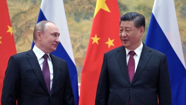 Russian President Vladimir Putin stands next to Chinese President Xi Jinping.