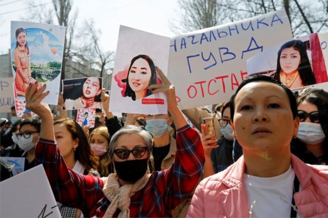 People hold placards during a rally in front of Kyrgyzstan's interior ministry after the murder of Aizada Kanatbekova