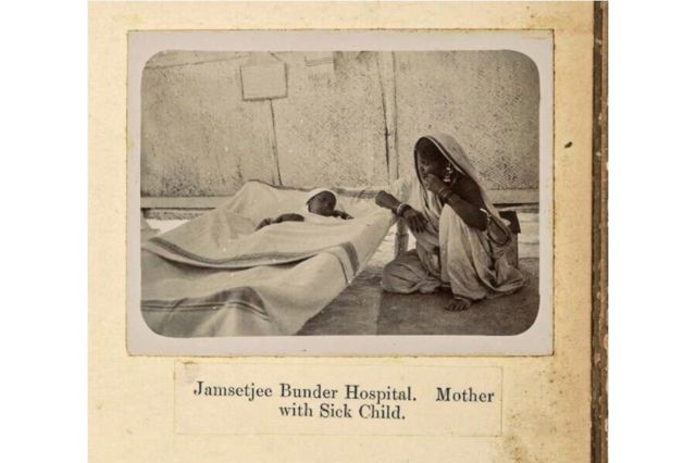 Mulher acompanha seu filho doente em um hospital indiano