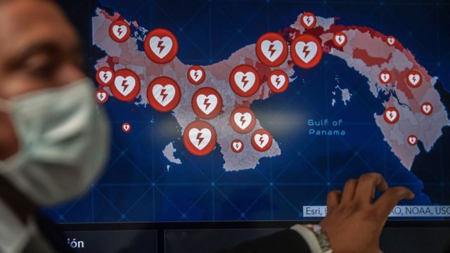 Un funcionario de salud de Panamá ante un mapa del país con puntos que marcan los centros de asistencia