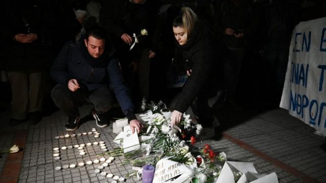 People lit candles and laid flowers outside the train station in Larisa on Wednesday