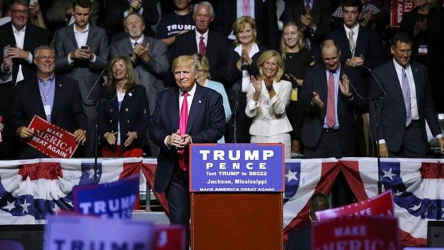 خانم فیچ که با لباس سفید در سمت راست آقای ترامپ در تصویر دیده می‌شود، رهبری ائتلاف زنان برای ترامپ در می‌سی‌سی‌پی را در سال ۲۰۱۶ بر عهده داشت