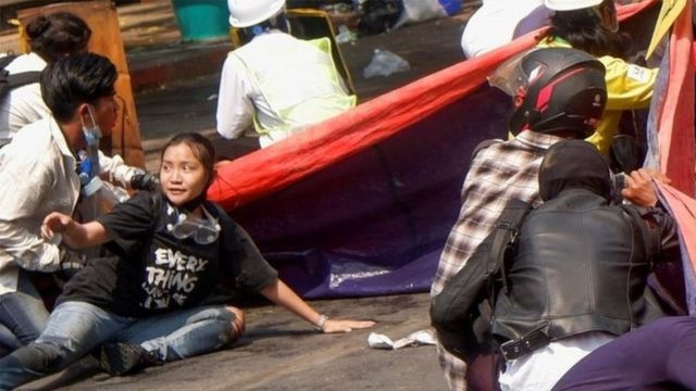 Protesters lie on the ground in Myanmar after troops opened fire