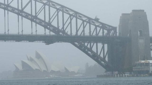 The Sydney Opera House and Sydney Harbour Bridge seen through a cloak of heavy rain