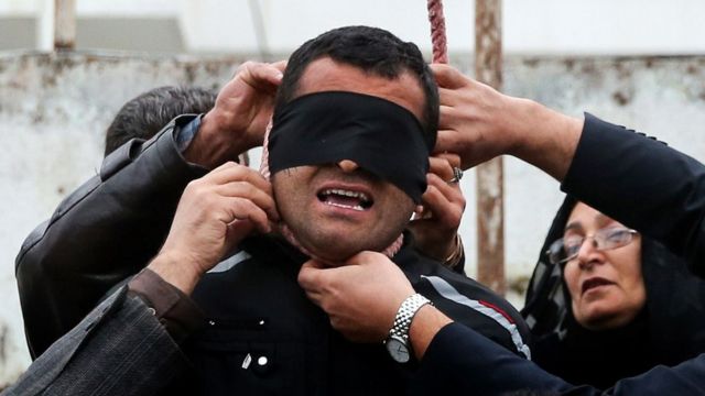 The mother (R) of Abdolah Hosseinzadeh, who was murdered in 2007, removes the noose with the help of her husband from around the neck of Balal, who killed her son