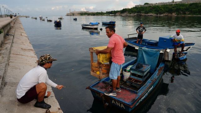 Pescadores cubanos guardan sus embarcaciones ante la llegada de Ian este lunes por la noche.