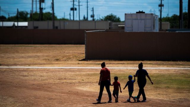 Duas mães caminham com seus filhos no Centro Residencial do Sul do Texas em 2019