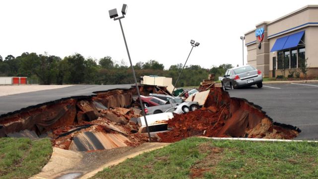 This photo shows vehicles after a cave-in of a restaurant parking lot in Meridian, Miss., Sunday, Nov. 8, 2015.
