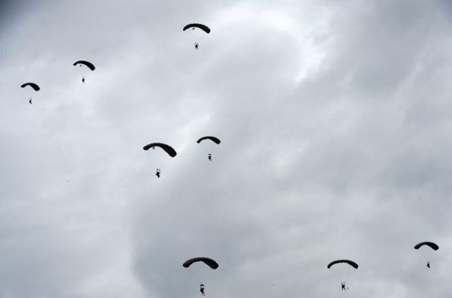 سربازان چترباز آمریکایی در حال فرود از یک هواپیمای هرکولس سی-۱۳۰ در ماه ژوئن سال ۲۰۲۲ در جریان جشن‌های هفتاد و هشتمین سالگرد نبرد نرماندی در جنگ جهانی دوم که سال ۱۹۴۴ در فرانسه رخ داد