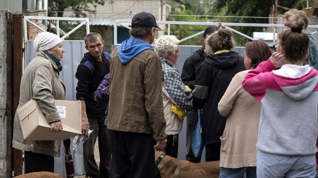 Gente en Izium recibiendo cajas con ayuda humanitaria