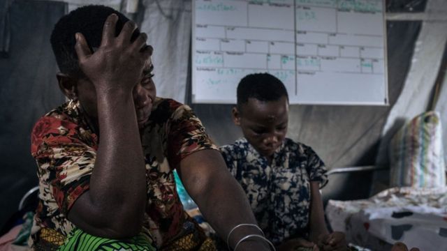Setoka Marasi (à gauche) se lamente sur l'état de sa fille (à droite), Noella, qui a été gravement blessée à la tête et au cou par des coups de machette lors de l'attaque de son village par des hommes armés au nord de Beni, dans le nord-est de la République démocratique du Congo, le 26 mai 2021.