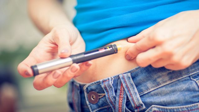 Mujer inyectándose insulina