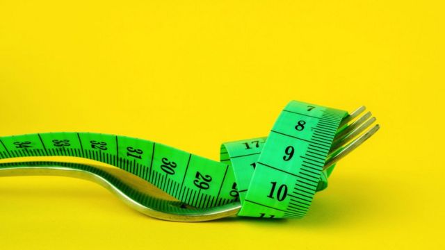 Tape measure wrapped around a fork.