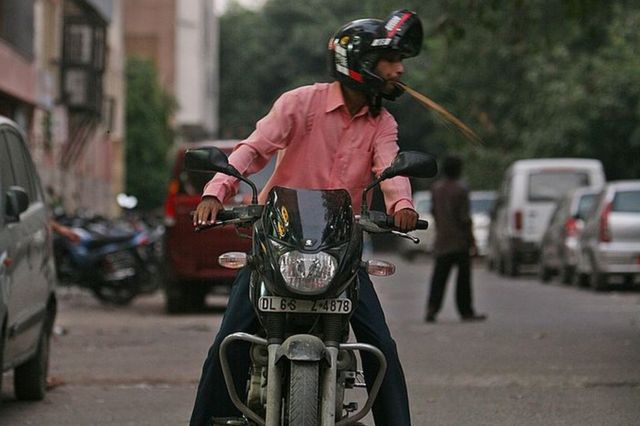 A motorcyclist spit on the street in New Delhi.