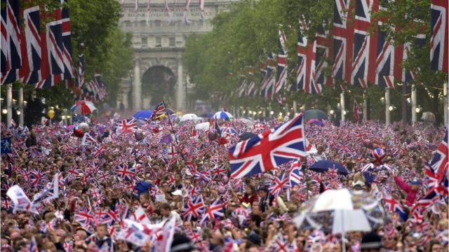 People wave flags along the Mall during the Queen's Golden Jubilee