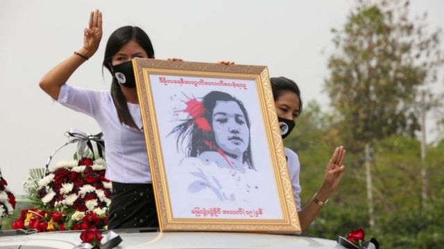 Myanmar women hold up a portrait of slain protester Mya Thwe Thwe Khaing