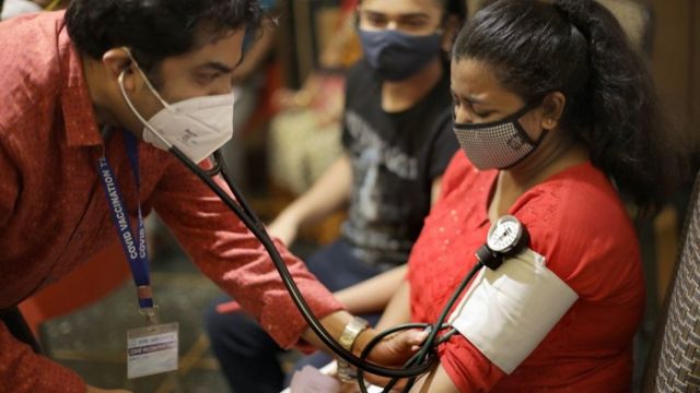 Un médecin examine une femme après avoir reçu une injection de vaccin COVID-19 lors d'une campagne de vaccination à Kolkata, dans l'est de l'Inde, le 22 juin 2021.
