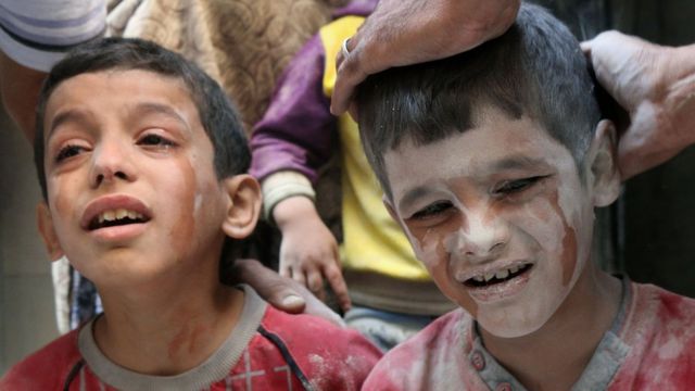 空爆後に救助されて泣く子どもたち（11日）