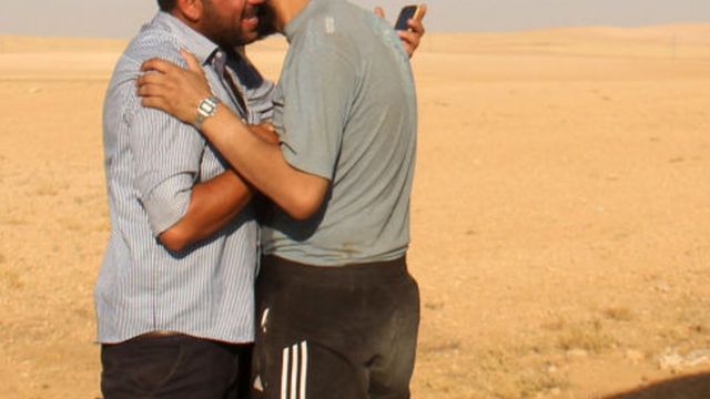Dua pria Suriah berpelukan setelah memasuki area yang dikuasai pemberontak.