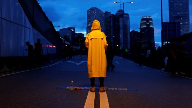 A protester wears a yellow raincoat to pay tribute to a man who died after falling from a scaffolding at the Pacific Place complex while protesting against the extradition bill, during a demonstration demanding Hong Kong"s leaders to step down and withdraw the extradition bill, in Hong Kong, China June 17, 2019. REUTERS/Tyrone Siu TPX IMAGES OF THE DAY