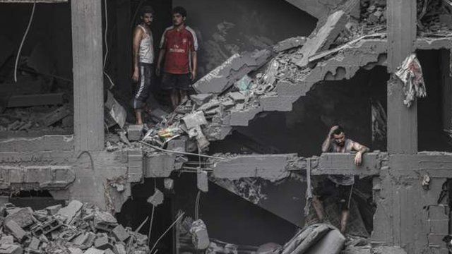 People in a damaged building in the Gaza Strip earlier today