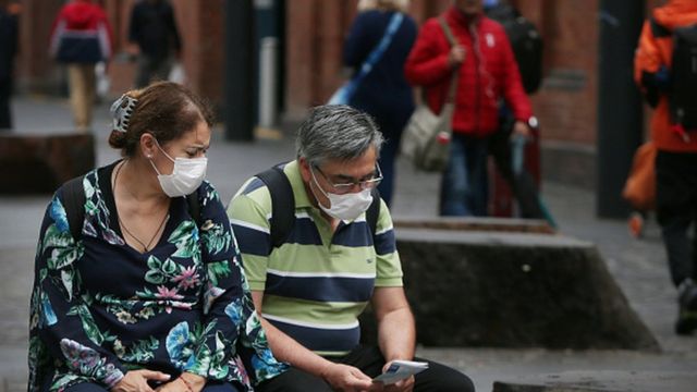 A man and a woman wear face masks in the Chinatown district of Sydney